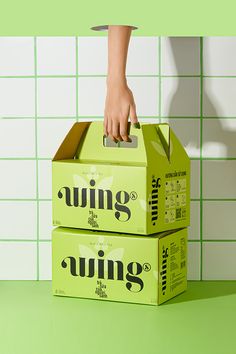 two boxes stacked on top of each other in front of a green tiled wall and floor