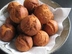 a white bowl filled with muffins on top of a table