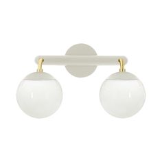 two white balls are hanging from a wall mounted light with gold trimmings on it