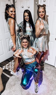 four girls in silver outfits posing for the camera