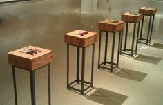 four wooden tables sitting on top of each other in a room with white walls and flooring