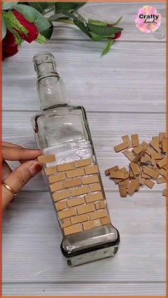 a bottle filled with lots of brown bricks next to a pile of small pieces of wood