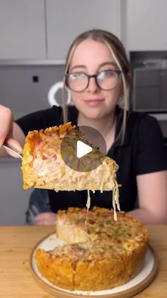 a woman eating a piece of pizza on top of a wooden table