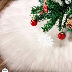 a christmas tree with ornaments hanging from it's branches and snowflakes on top