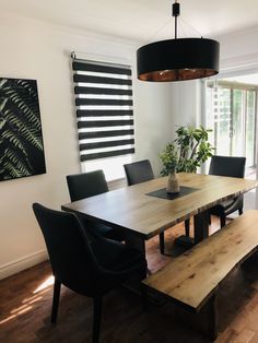 a dining room table with black chairs and a bench