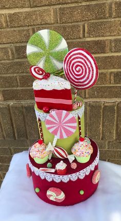 a three tiered cake decorated with candy and lollipops