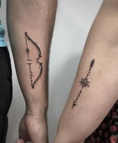 two people holding hands with tattoos on their arms, one has a bow and arrow