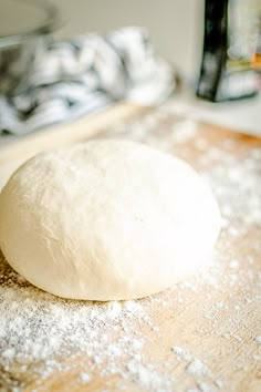 a ball of dough sitting on top of a wooden cutting board