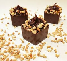 three pieces of chocolate with nuts on top