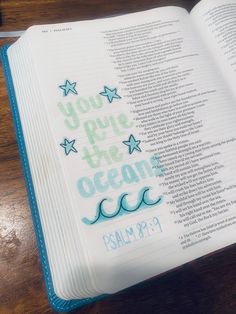 an open bible with the words you are the ocean written in blue and green on it