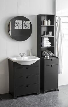 a black and white bathroom with a sink, cabinet and mirror on the wall next to it