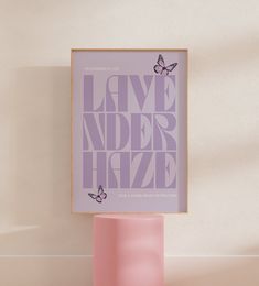 a pink vase sitting next to a purple poster on a white wall in a room