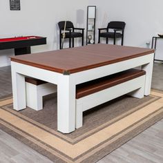 a pool table and two chairs in a room with a rug on the floor next to it