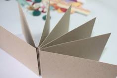 an open book sitting on top of a table next to scissors and other crafting supplies