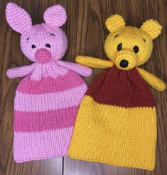 two knitted teddy bears sitting next to each other on top of a wooden floor