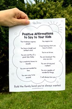 a person holding up a sign that says positive affirmationss to say to your kids