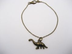 Dinosaur bracelet.Comes on a  brass , lead, and nickel free chain.Dino  charms are 14x27x3.5mm lead, and nickel free.Closes with a lobster claw clasp.Ruler is there to show size.Choose the length you prefer during checkout.I hand make each item with love and care.I package each piece of jewelry in a colorful organza bag.Ready for gift giving or gifting  yourself.To see all of my dinosaur jewelry, click here.https://www.etsy.com/shop/RevelryJewelry/search?search_query=dinosaur&order=date_desc&vie Dino Bracelet, Dinosaur Bracelet, Compass Keychain, Dinosaur Jewelry, Mother Daughter Necklace, Mother Daughter Gifts, Witch Jewelry, Daughter Necklace, Brass Chain