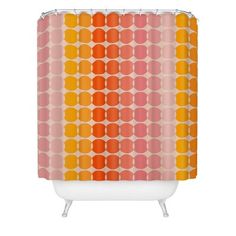 a shower curtain with an orange and pink pattern on the outside, in front of a white