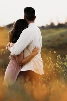 a man and woman embracing in a field