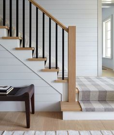 there is a stair case next to the carpet on the floor in this living room