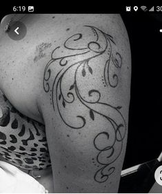 black and white photo of a woman's arm with an ornate tattoo on it