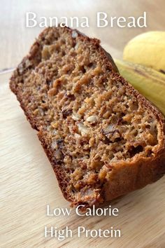 a banana bread sitting on top of a wooden cutting board next to a ripe banana