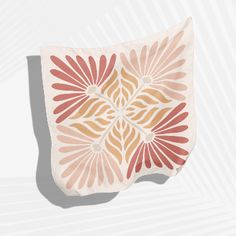 an orange and pink flower design on a white wall hanging from the side of a room