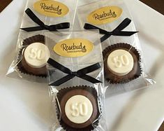 four chocolates wrapped in cellophane and tied with black ribbon