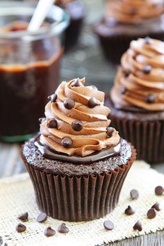 two chocolate cupcakes with frosting and chocolate chips