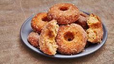 a blue plate topped with donuts covered in sugar