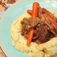 a blue plate topped with meat and mashed potatoes