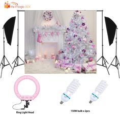 a christmas tree with pink and white lights in front of it, next to two photography lighting