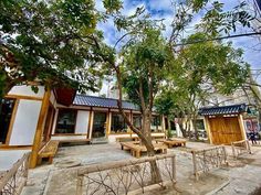 an outdoor seating area with benches and trees