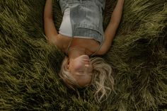 a woman laying on her back in the grass