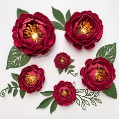 paper flowers with leaves and stems arranged in the shape of three large pink peonies