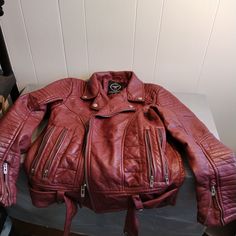 "This is pre owned and gently worn. The only think I can find is a few fabric fuzzies on the lining. Condition is very good. Red is darker. This is a heavier jacket. Belt around bottom. 25\" long. 22\" pit to pit. 20 1/2\" side to side at bottom." Casual Red Outerwear For Biker Events, Red Zipper Outerwear For Biker Events, Red Long Sleeve Outerwear For Biker Events, Red Leather Jacket For Biker Events In Fall, Red Fall Biker Jacket For Biker Events, Burgundy Long Sleeve Biker Jacket For Winter, Red Zipper Closure Outerwear For Biker Events, Red Moto Outerwear For Winter, Red Punk Leather Jacket For Fall