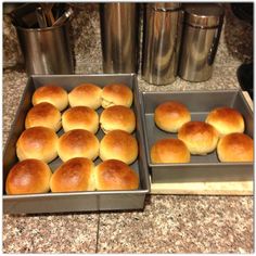 two pans filled with rolls sitting on top of a counter