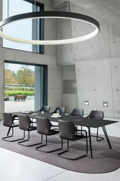 a large table with chairs around it in front of a window and cow grazing on the other side