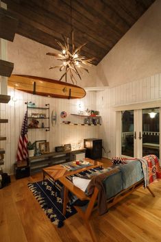 a living room filled with furniture and a fire place under a ceiling fan on top of a wooden floor