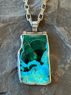 Tapestry Pendant Exceptional Azure-Malachite freeform tablet bezel set in texturized, oxidized Sterling Silver with 14K yellow gold accents. The top of the pendant is hinged so the tablet hangs like a lush colored tapestry. The solid Sterling Silver rectangular link chain is 18” with a lobster claw clasp. Links are 6.3 mm x 3.2 mm Pendant measures approx. 2” x 1” Unisex statement necklace Listed as a set and includes the chain. Other Chan lengths available upon request. Luxury Artisan Necklace With Inlay, Green Chrysocolla Jewelry With Large Pendant, Artisan Malachite Jewelry Gift, Green Chrysocolla Pendant Jewelry, One Of A Kind Artisan Rectangular Jewelry, One Of A Kind Rectangular Artisan Jewelry, Artisan Rectangular Green Jewelry, Artisan Green Rectangular Jewelry, Green Rectangular Artisan Jewelry