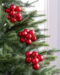 a christmas tree with red ornaments hanging from it's branches