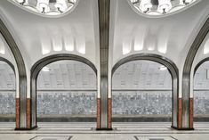 an empty subway station with arches and tiled floor