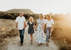 a family walking down a dirt road holding hands