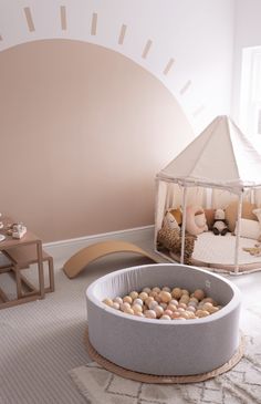 a baby's room with pink walls and white carpeted flooring, an infant crib in the center