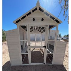 a small white building sitting on top of a dirt field