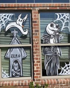 two windows decorated with halloween decorations and skeleton figures, one is painted black and white