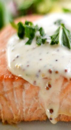 a piece of salmon covered in white sauce