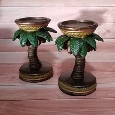 two metal candlesticks with palm trees on them