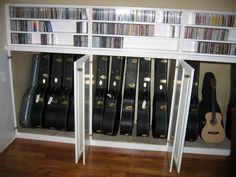 a book shelf filled with lots of books next to a guitar