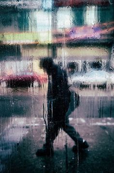 a person walking in the rain with an umbrella